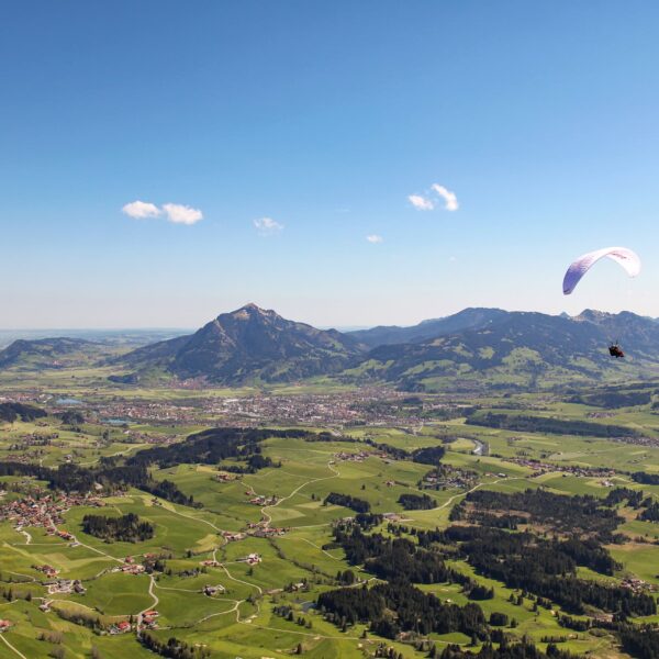 Two tandem paragliders over Bolsterlang with a view of the Illertal and Grünten