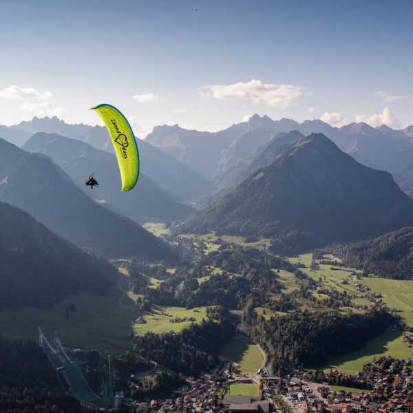 Tandem paragliding in a wingover against the Oberstdorf mountain backdrop