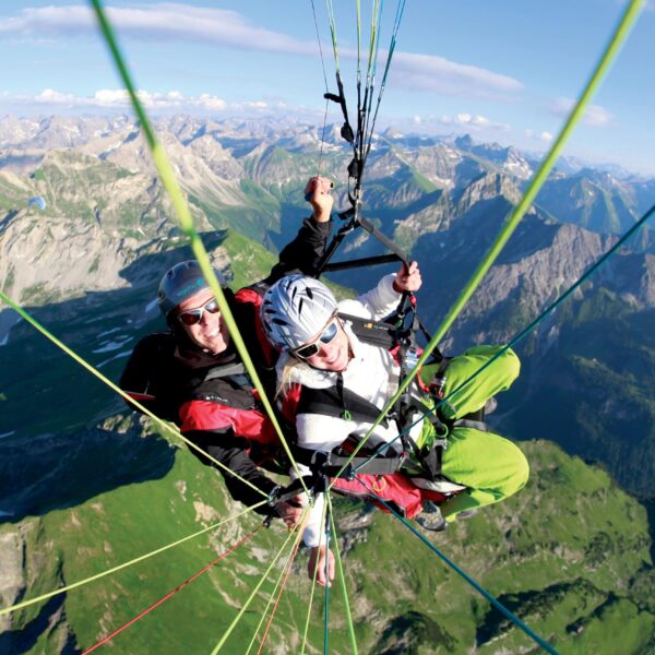 Tandem paraglider pilot and passenger over Oberstdorf peaks